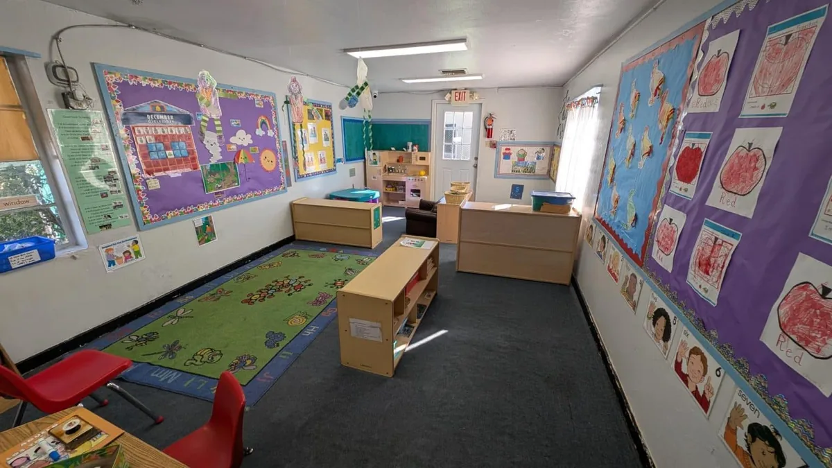 Preschool room with a reading rug, bulletin boards and children’s artwork
