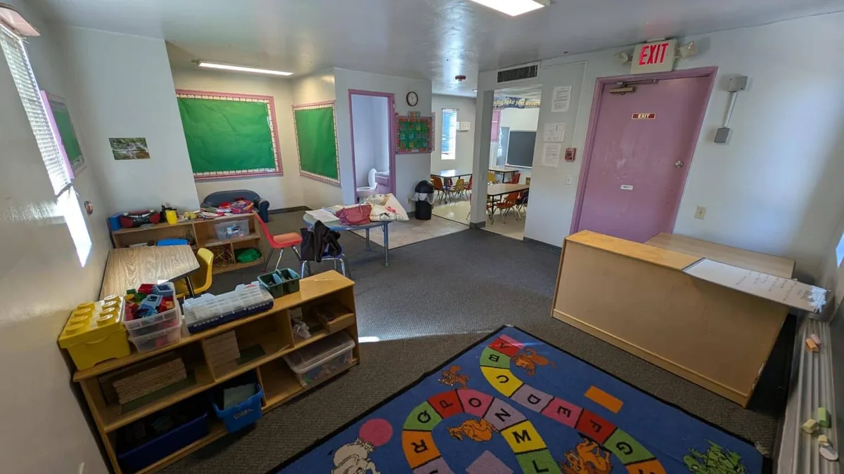 Toddler room with block shelves, an alphabet rug and a quiet corner